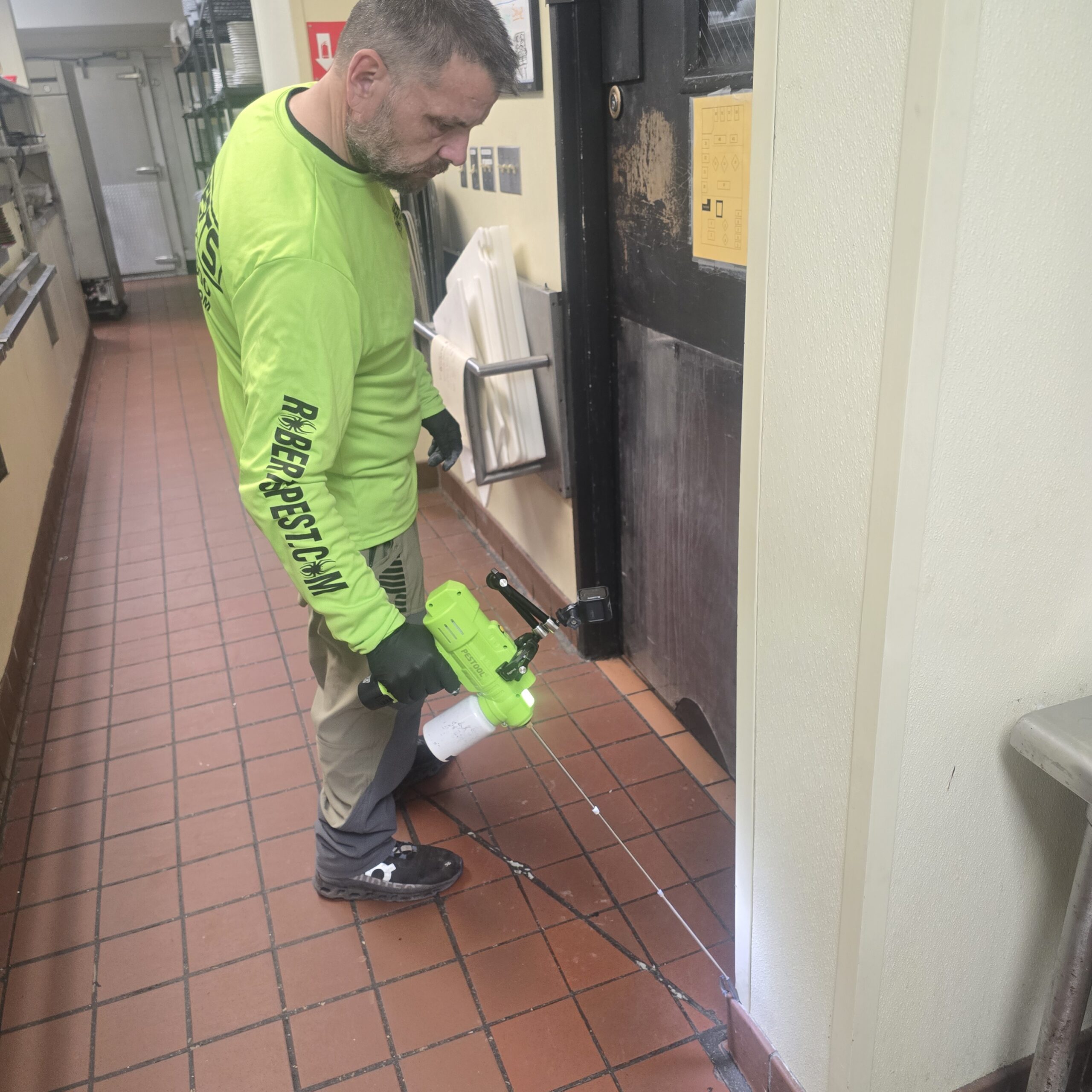 Roberts Pest Control technician treating a commercial kitchen