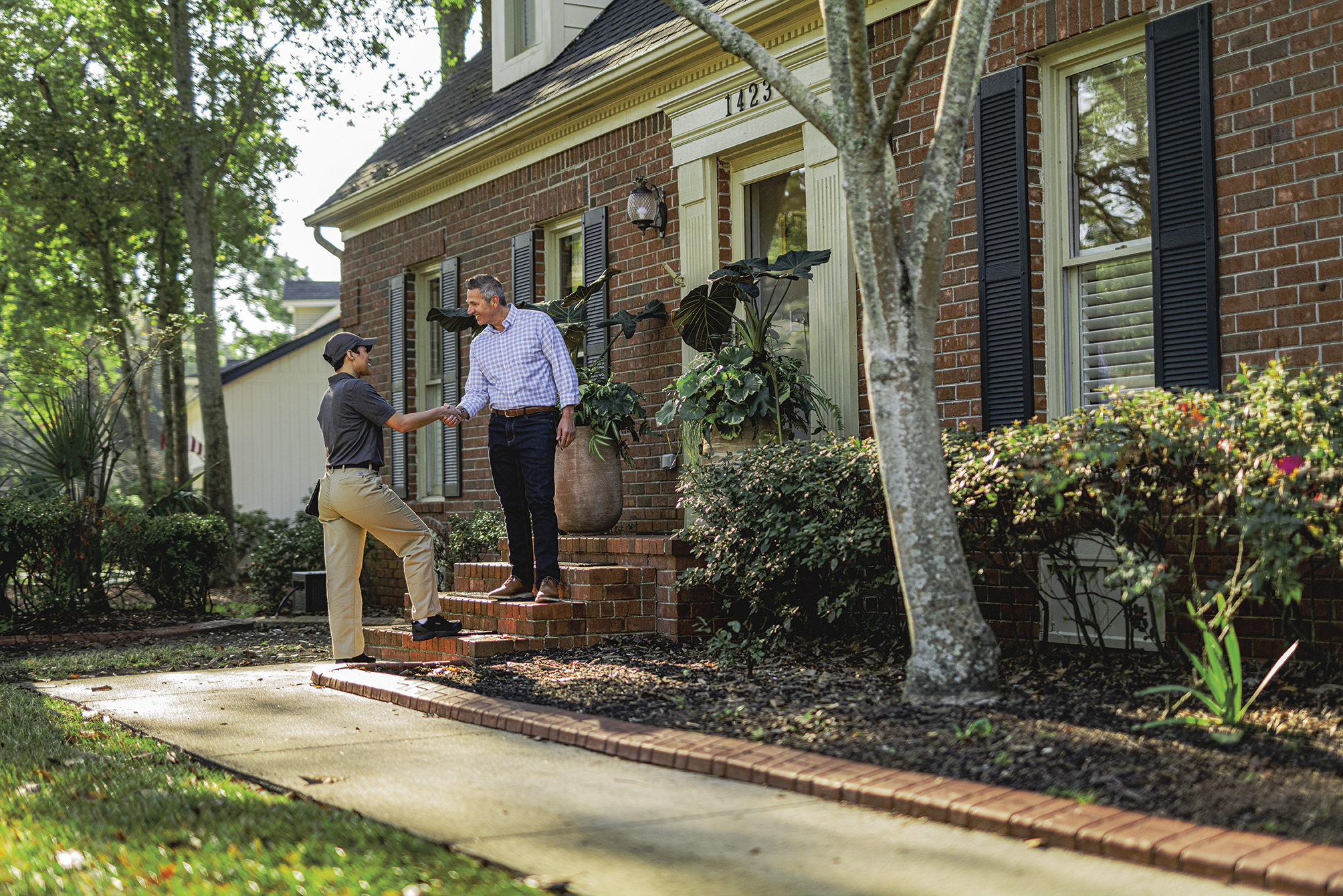 Roberts Pest Control technician arriving at brick home in St. Louis for annual Sentricon station inspection