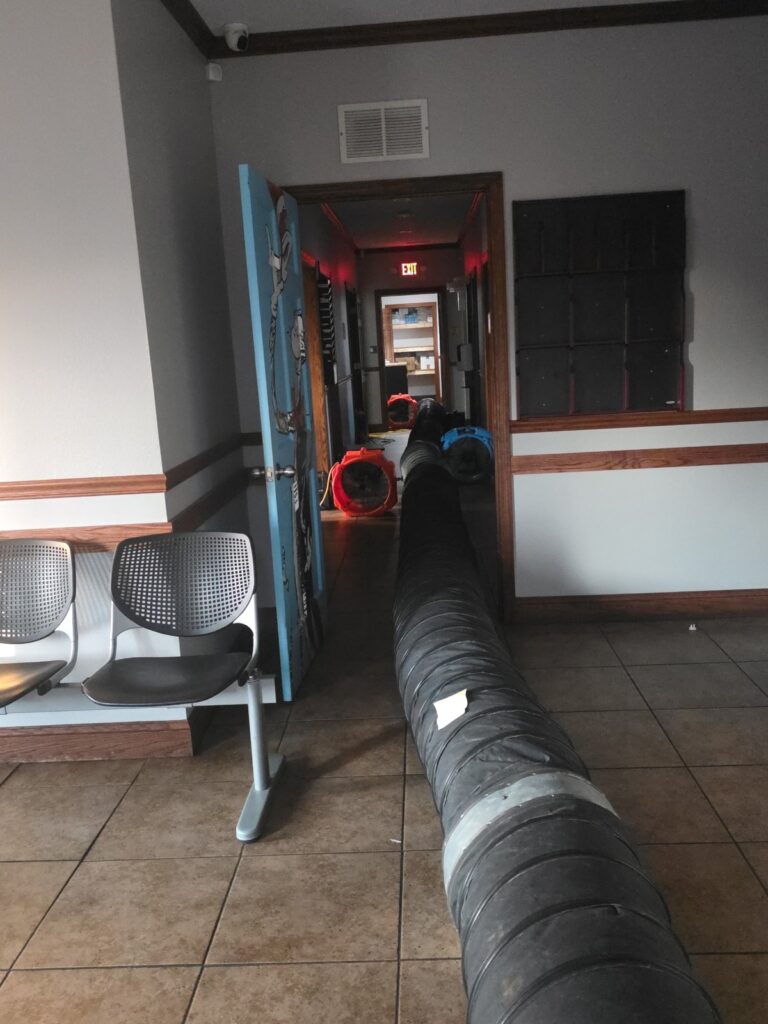 Interior of a commercial building during bed bug heat treatment with Roberts Pest Control heat ducting running down the hallway and orange air movers circulating heat