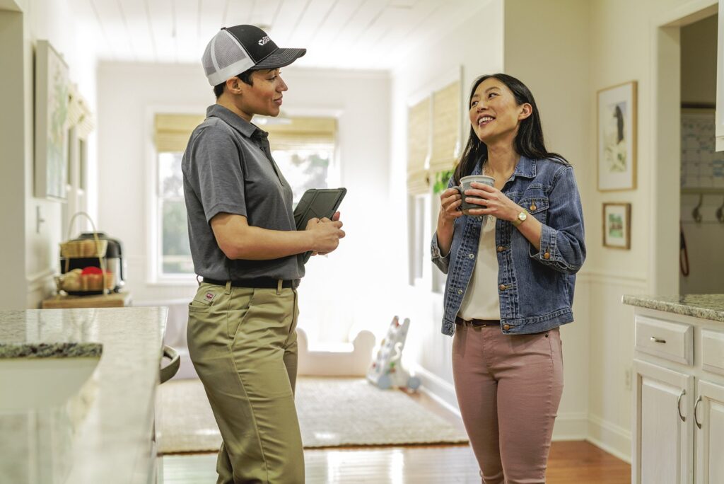A pest control professional reviewing a digital inspection report with a client